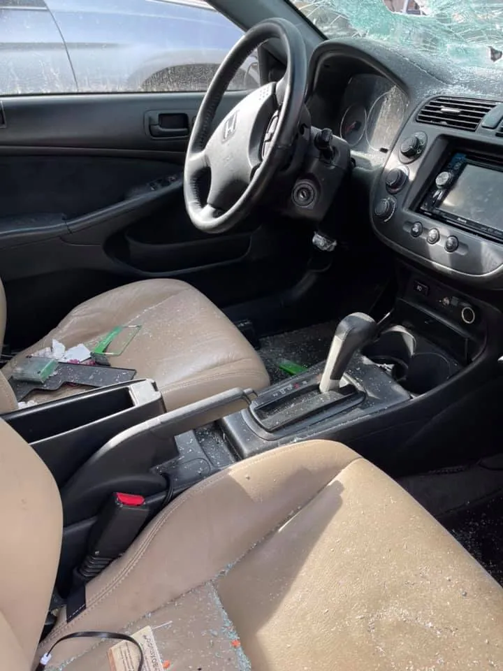 Donor car interior at an Indianapolis salvage yard with trim, glove box, and console parts still intact
