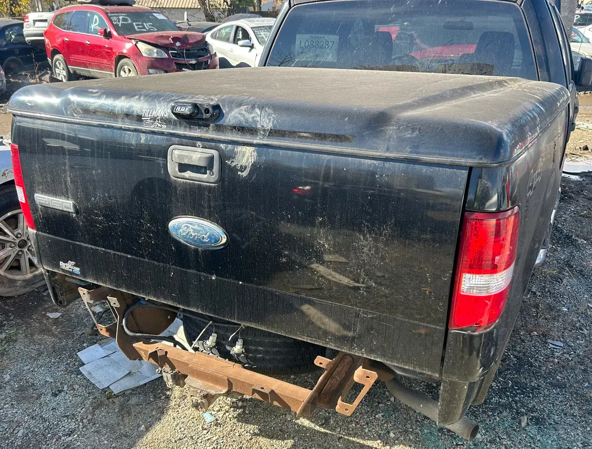 Black Ford F-150 in a salvage row with its bumper removed -- popular trucks earn self-service yards steady pull-it-yourself sales